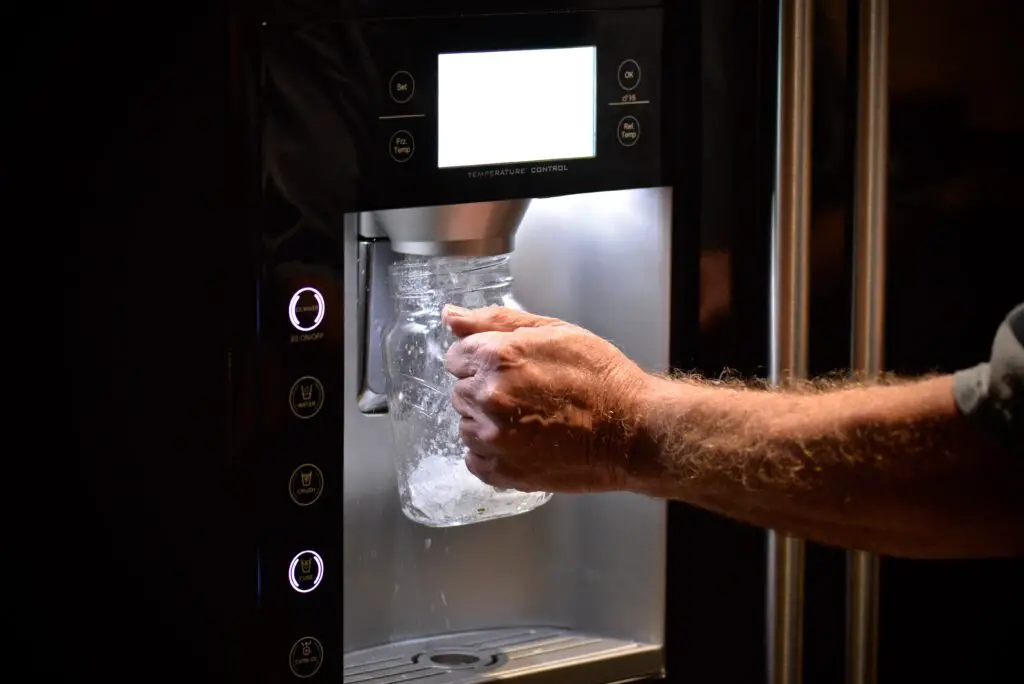 man grabbing ice - whirlpool fridge won't stop dispensing ice