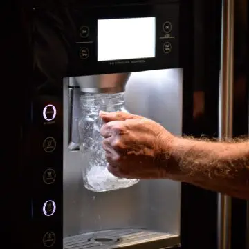 man grabbing ice - whirlpool fridge won't stop dispensing ice